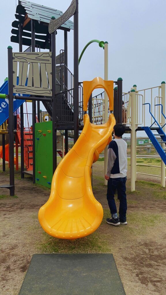 大間近隣公園(大間見晴らしの丘)の小学生向けの大型複合遊具の黄色い短めのすべり台
