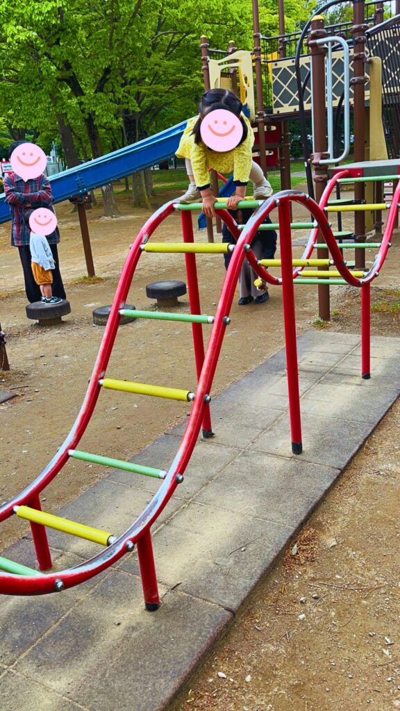 岩槻城址公園のわんぱく広場内にある小学生向け複合遊具の湾曲した梯子で遊ぶ子供
