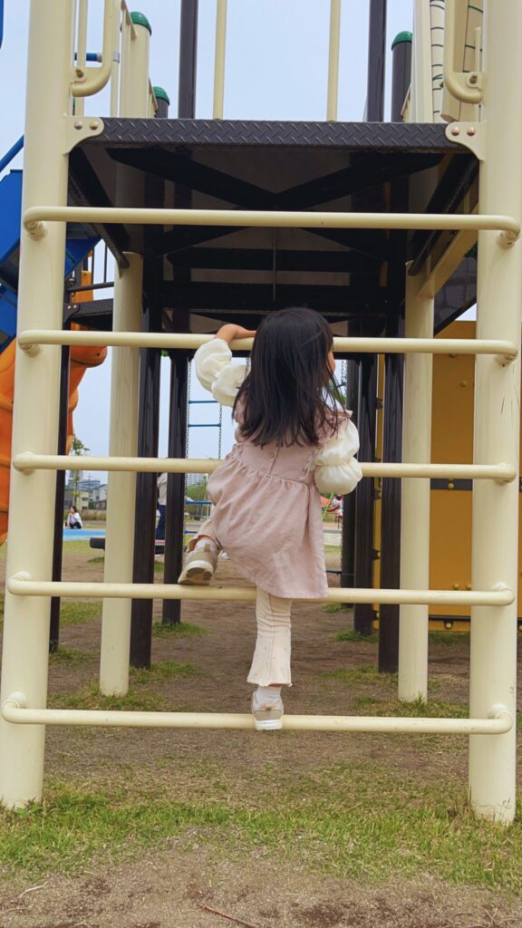 大間近隣公園(大間見晴らしの丘)の小学生向けの大型複合遊具のはしご型のステップを登る子ども