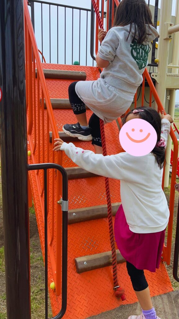 大間近隣公園(大間見晴らしの丘)の小学生向けの大型複合遊具のロープ登りをする子どもたち