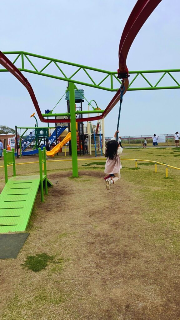 大間近隣公園(大間見晴らしの丘)の一周できるロープウェイ遊具にぶら下がる子ども