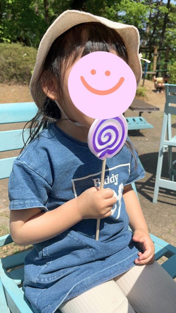埼玉県子ども動物自然公園のテラス席でぺろぺろキャンディを食べる子ども