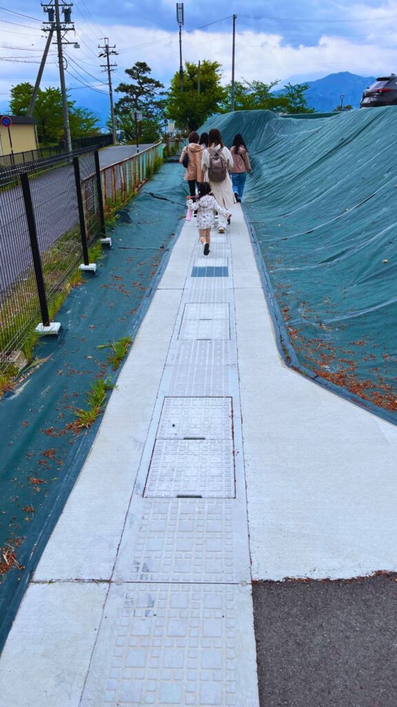 長野市城山公園第3駐車場北側のスロープを歩く人々