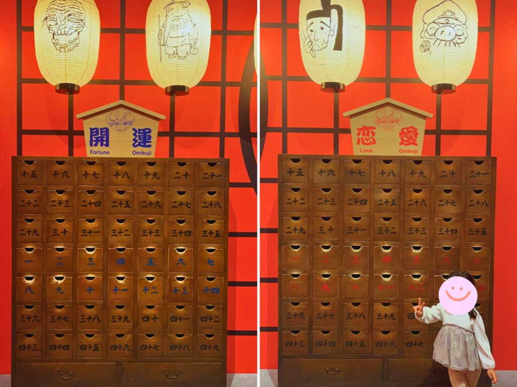 鈴木敏夫とジブリ展内の千と千尋の神隠しに登場する薬棚の前でピースをする子ども