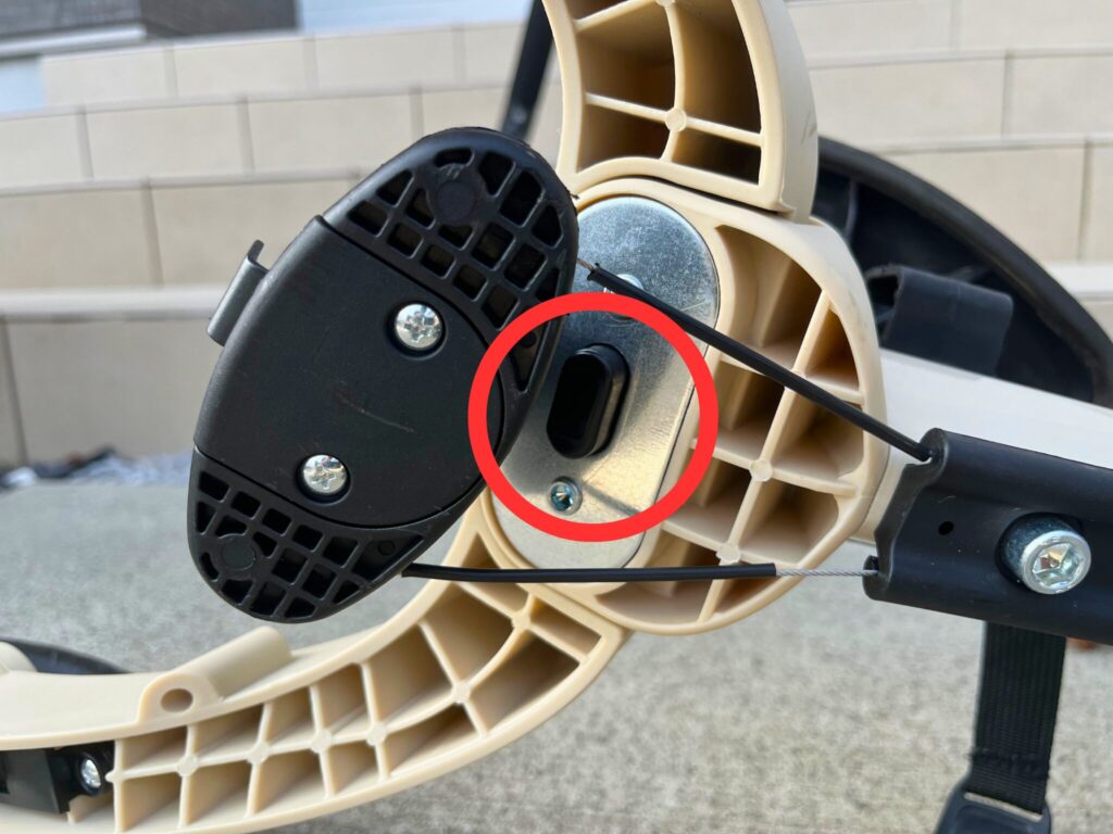ヤトミののりかえ三輪車の足の向きを変えるためのサドル裏のボタン
