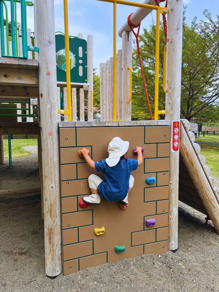 地附山公園の大型複合遊具-ボルダリング遊具で遊ぶ子供