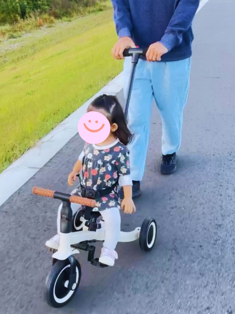 ヤトミののりかえ三輪車に乗る子どもと押し棒を操作する親
