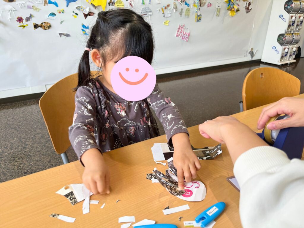 刈谷市美術館レオレオーニ展のフリーワークショップで紙を貼る子ども